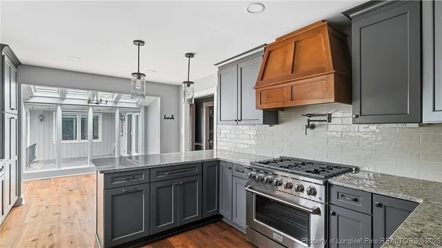 a kitchen with granite countertop a stove a sink and a granite counter tops