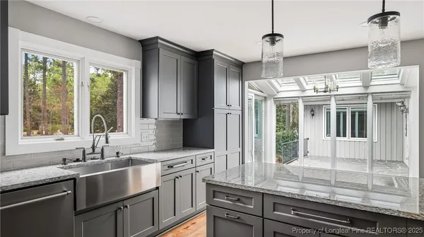 a kitchen with stainless steel appliances granite countertop a sink and a window