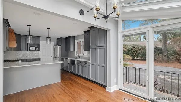 a large kitchen with stainless steel appliances granite countertop a refrigerator a sink and a stove