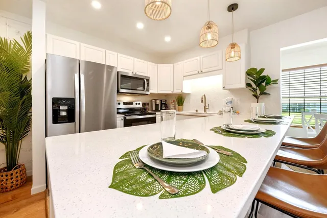 a kitchen with kitchen island granite countertop a stove and white cabinets