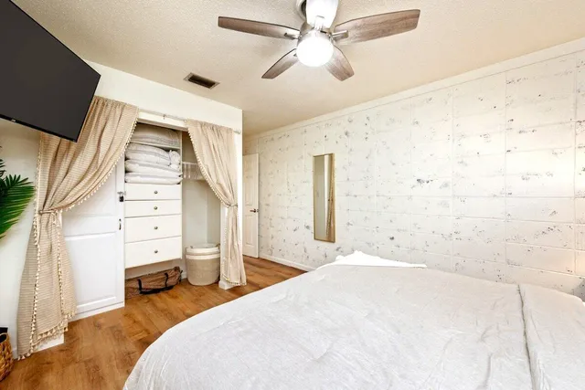 a bedroom with a bed and a flat tv screen on the dresser