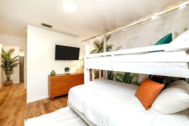 a bedroom with a bed and flat screen tv