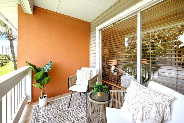 a view of a porch with furniture and a backyard