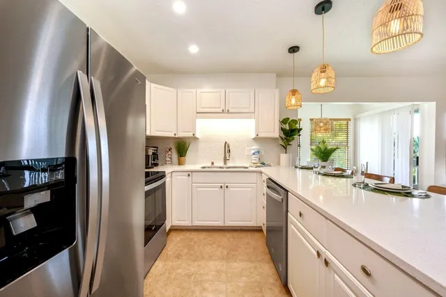 a kitchen with a sink refrigerator and window