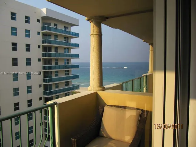 a view of a balcony with wooden floor and fence