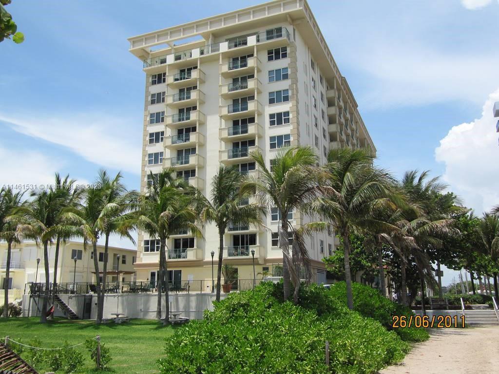 9195 Collins Avenue, Unit 613 Surfside, FL 33154 - Photo 7 of 13 a front view of multi story residential apartment building with yard and entryway