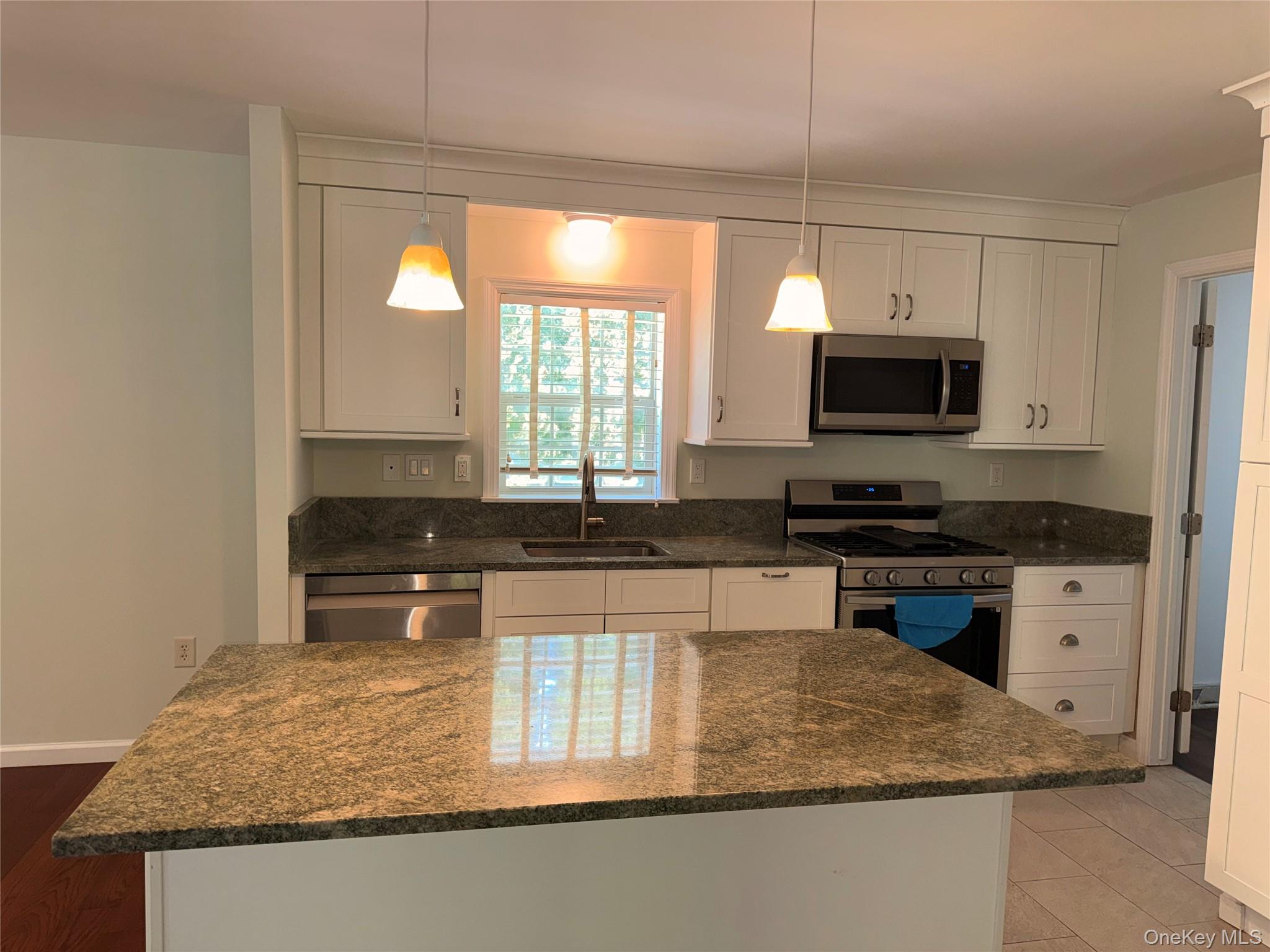 1661 Old Country Road, Unit 516 Riverhead, NY 11901 - Photo 14 of 50 a kitchen with stainless steel appliances granite countertop a sink stove and microwave