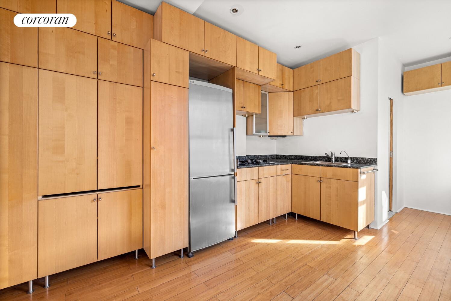 175 Rivington Street, Unit 1D Manhattan, NY 10002 - Photo 2 of 5 a kitchen with granite countertop white cabinets and refrigerator