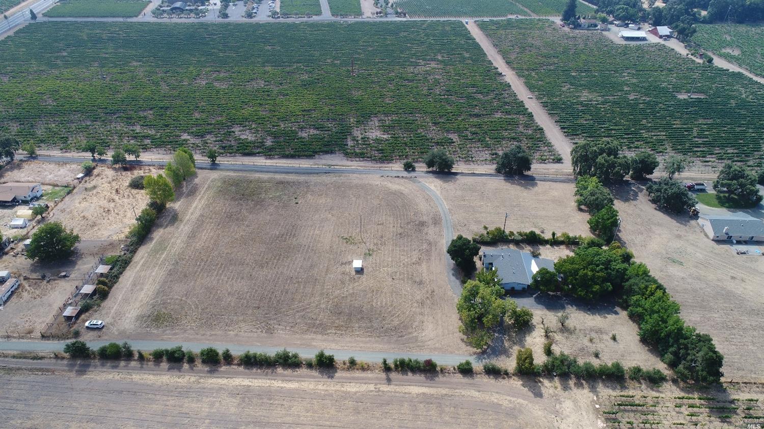 an aerial view of a house with a yard and lake view