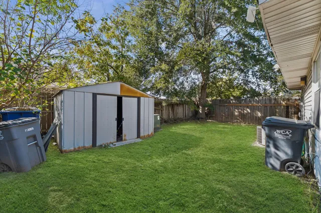 a view of a backyard with barn and large trees