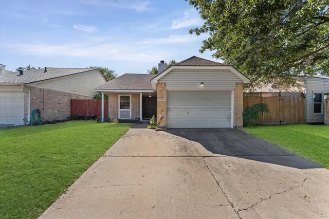 a front view of a house with a garden and trees