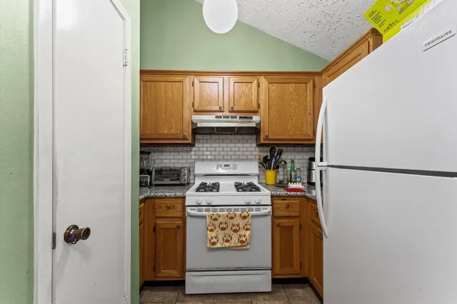 a kitchen with stainless steel appliances granite countertop a refrigerator and a stove