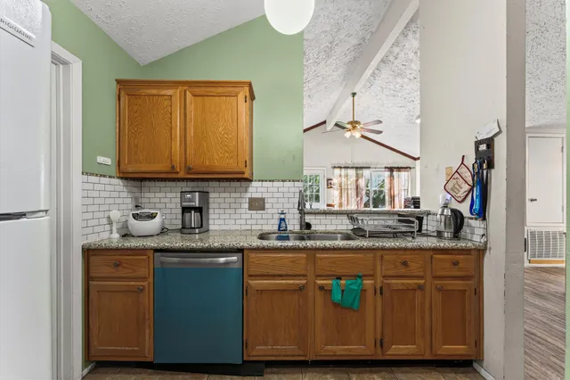 a kitchen with granite countertop a sink a stove and cabinets