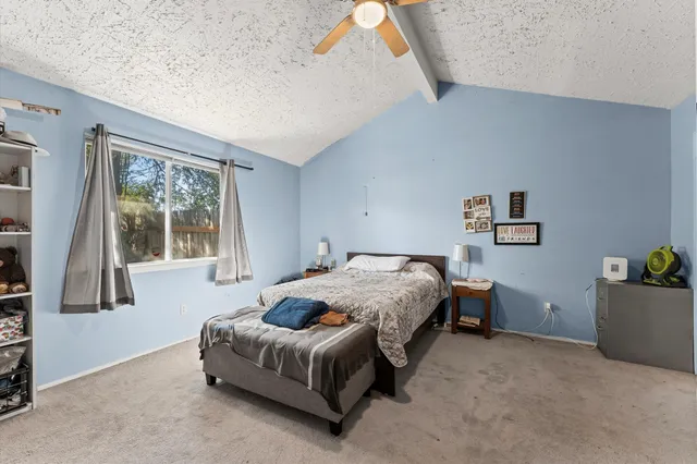 a spacious bedroom with a bed and a window