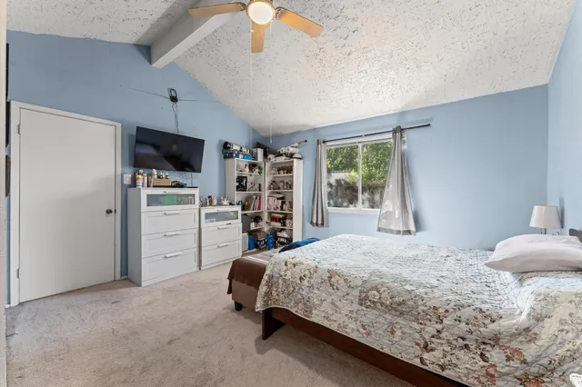 a spacious bedroom with a bed and a flat screen tv