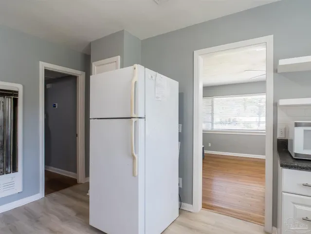 a white refrigerator freezer and a stove sitting inside of a kitchen