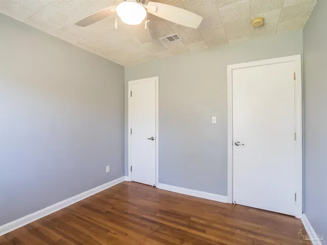 a view of an empty room with wooden floor