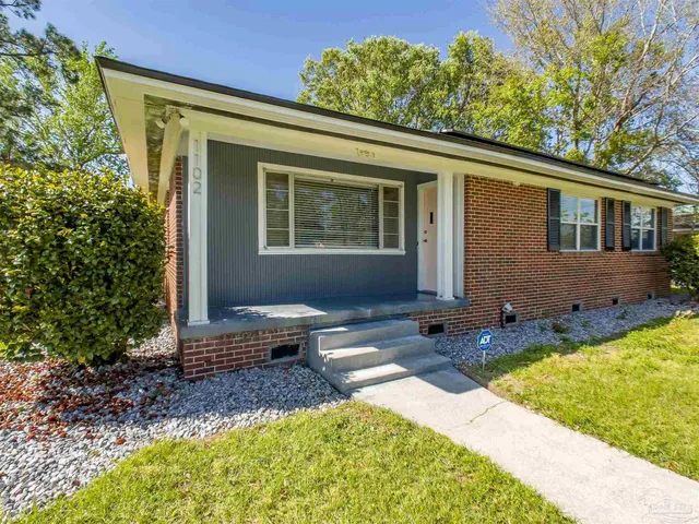 a view of a house with backyard and sitting area