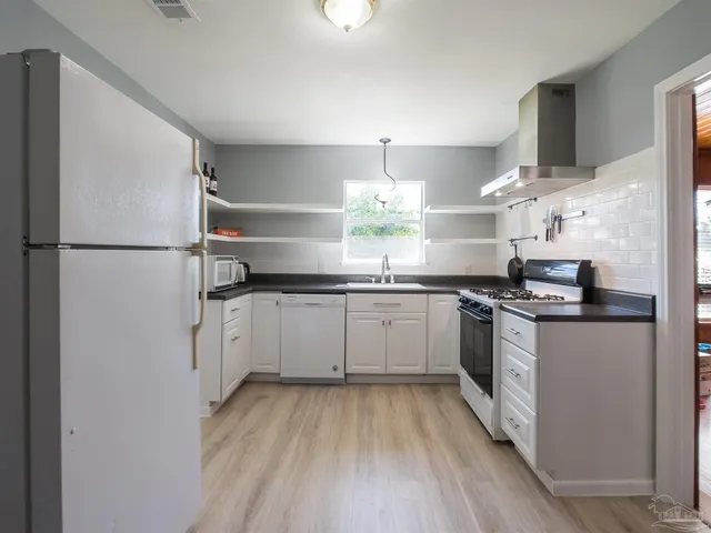 a kitchen with a sink stainless steel appliances and white cabinets
