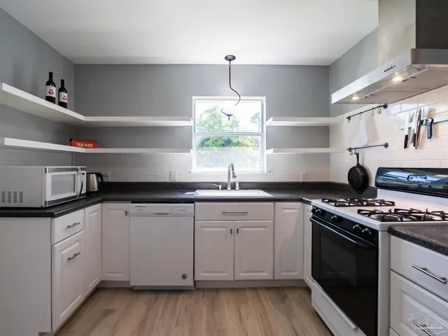 a kitchen with cabinets a sink and appliances