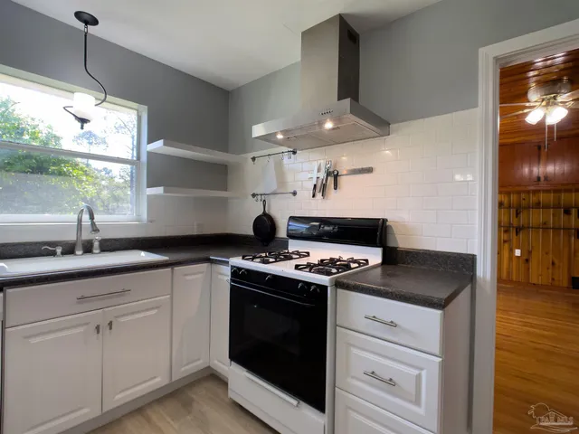 a kitchen with stainless steel appliances granite countertop a sink and a stove