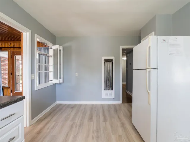 a view of a kitchen with wooden floor and refrigerator
