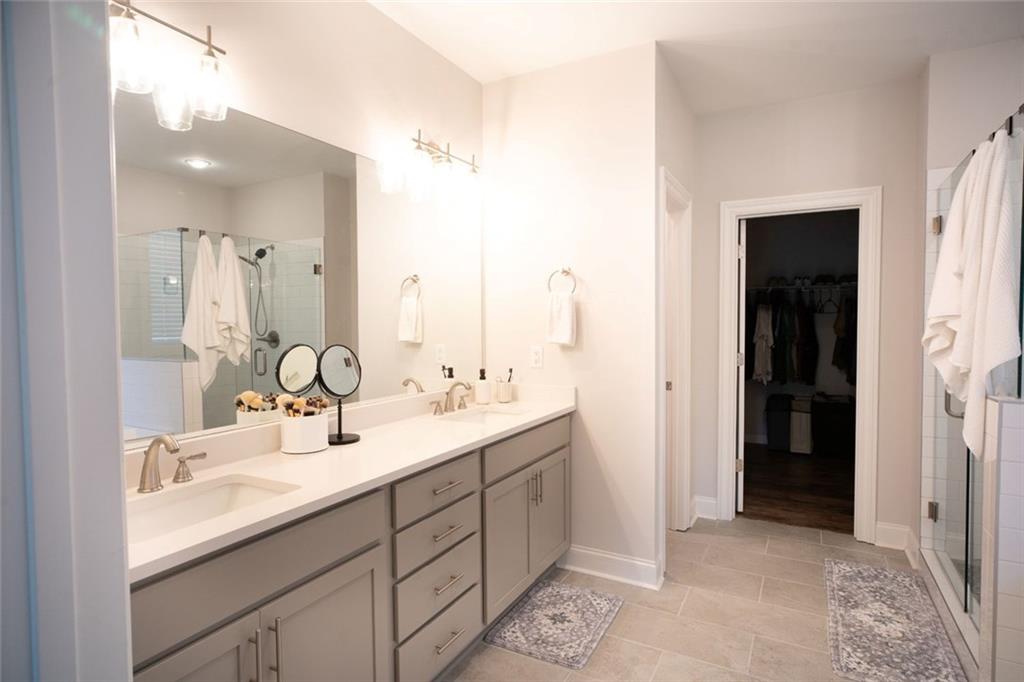 6165 Namon Wallace Road Cumming, GA 30028 - Photo 15 of 30 a bathroom with a double vanity sink and mirror