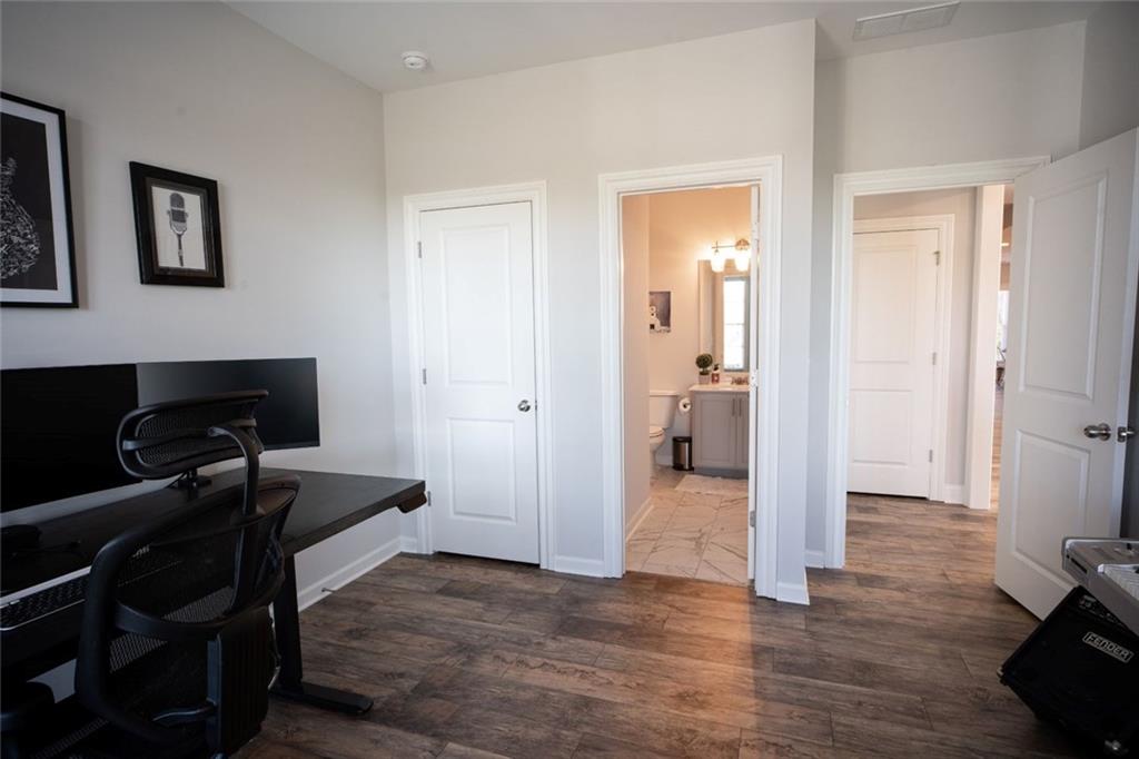 6165 Namon Wallace Road Cumming, GA 30028 - Photo 18 of 30 a view of a livingroom with wooden floor and a workspace