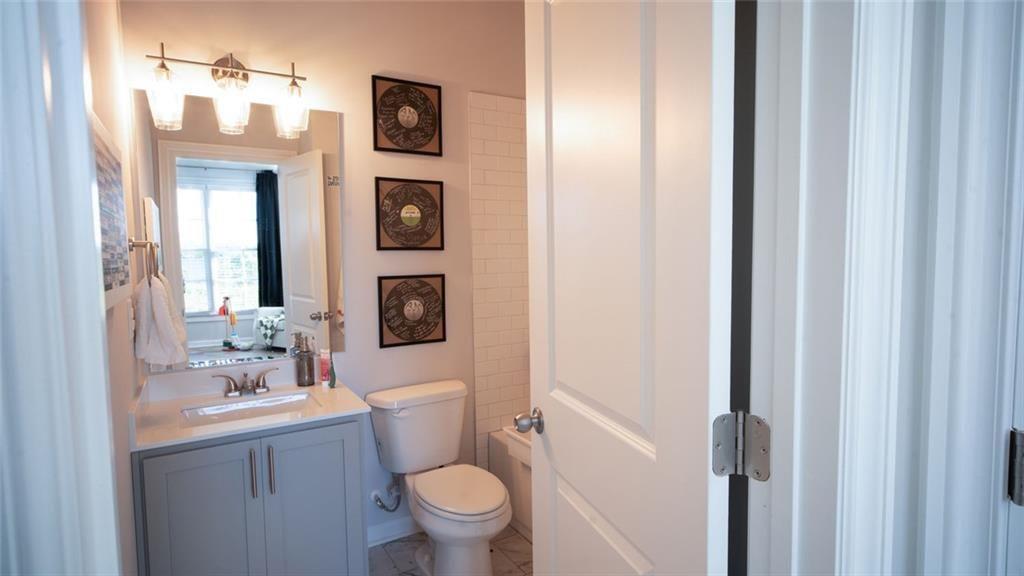 6165 Namon Wallace Road Cumming, GA 30028 - Photo 22 of 30 a bathroom with a toilet sink and mirror