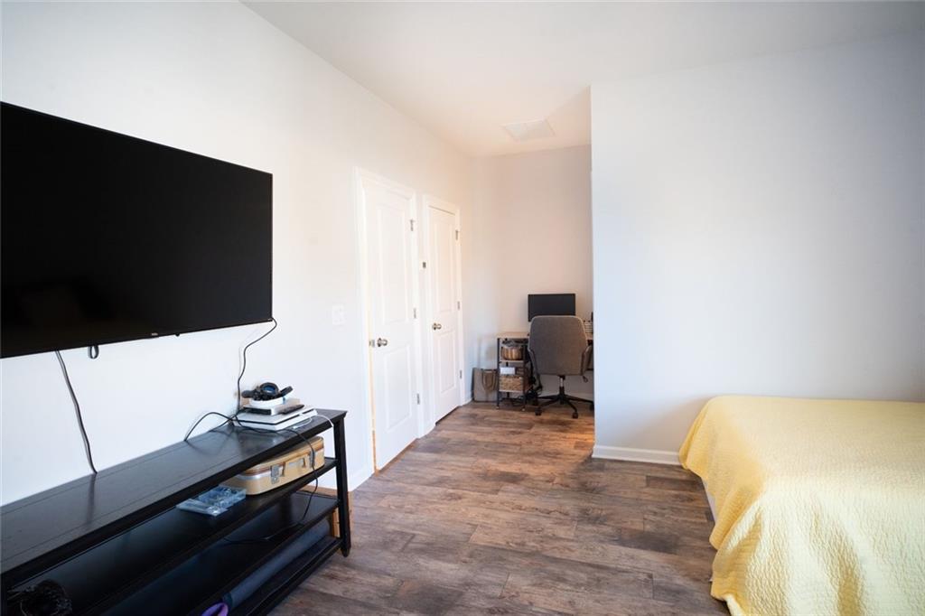 6165 Namon Wallace Road Cumming, GA 30028 - Photo 24 of 30 a bedroom with a bed and a flat screen tv