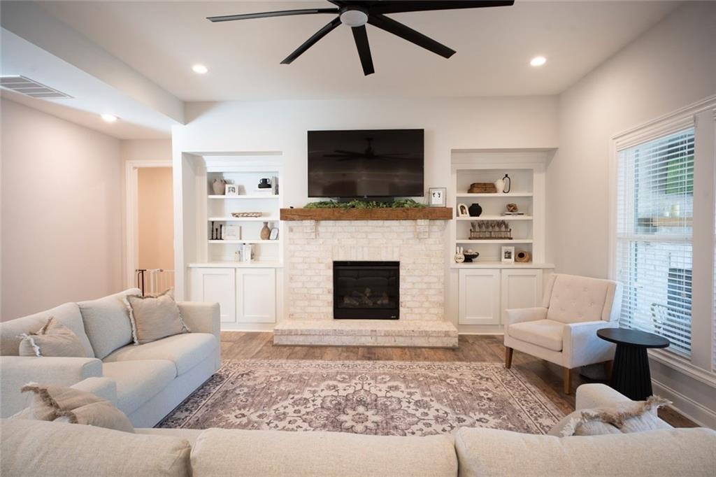 6165 Namon Wallace Road Cumming, GA 30028 - Photo 5 of 30 a living room with furniture a flat screen tv and a fireplace
