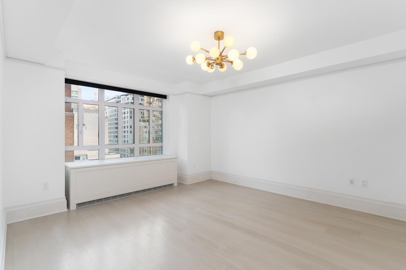 21 East 61st Street, Unit 9C Manhattan, NY 10065 - Photo 15 of 19 wooden floor in an empty room with a window