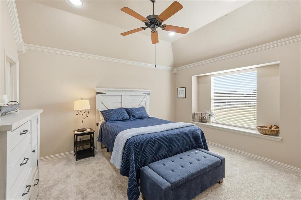 209 Lonesome Prairie Trail Haslet, TX 76052 - Photo 19 of 40 a bedroom with a bed and a chandelier