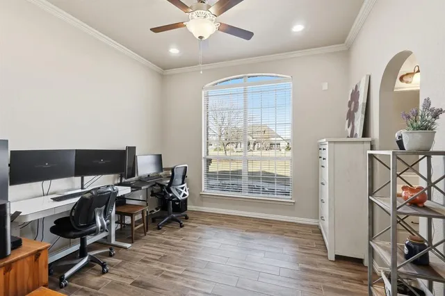 a view of a workspace with wooden floor and a window
