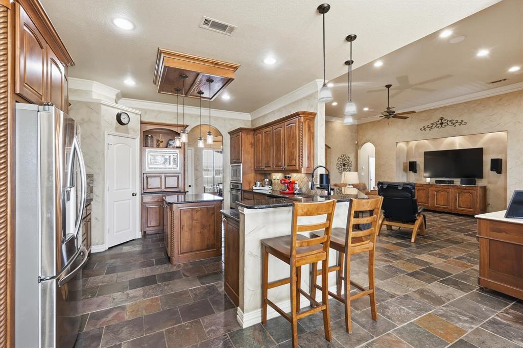 209 Lonesome Prairie Trail Haslet, TX 76052 - Photo 9 of 40 a kitchen with a dining table chairs and refrigerator