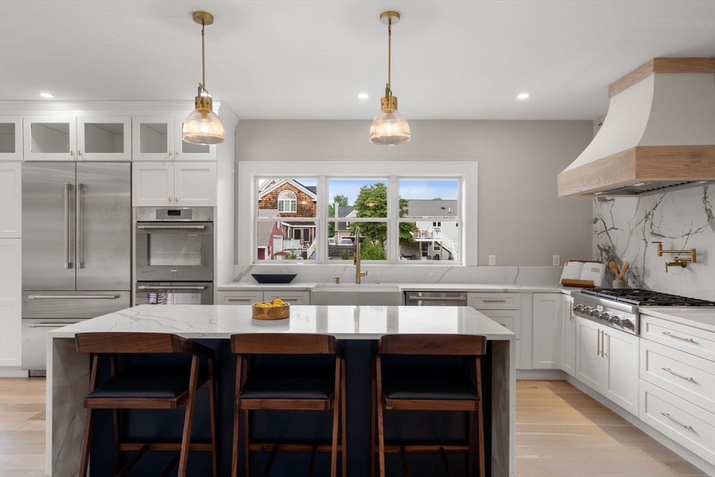 48 Cypress Road Milton, MA 02186 - Photo 14 of 39 a kitchen with a dining table chairs sink and stove