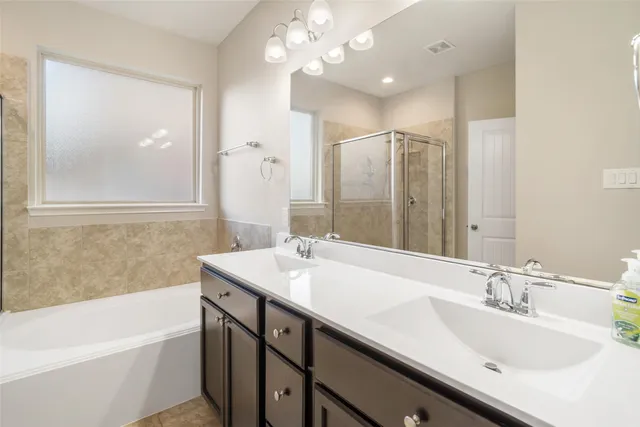 a bathroom with a tub a sink and mirror