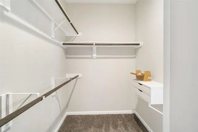 a view of walk in closet with empty racks