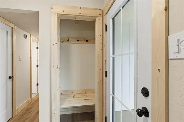 a view of an empty room with a window and wooden floor