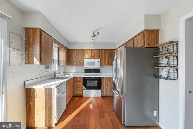 a kitchen with stainless steel appliances granite countertop a refrigerator and a sink