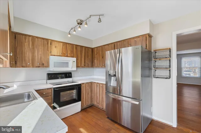 a kitchen with stainless steel appliances a refrigerator sink and microwave