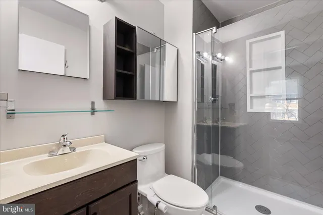 a bathroom with a sink toilet a mirror and shower