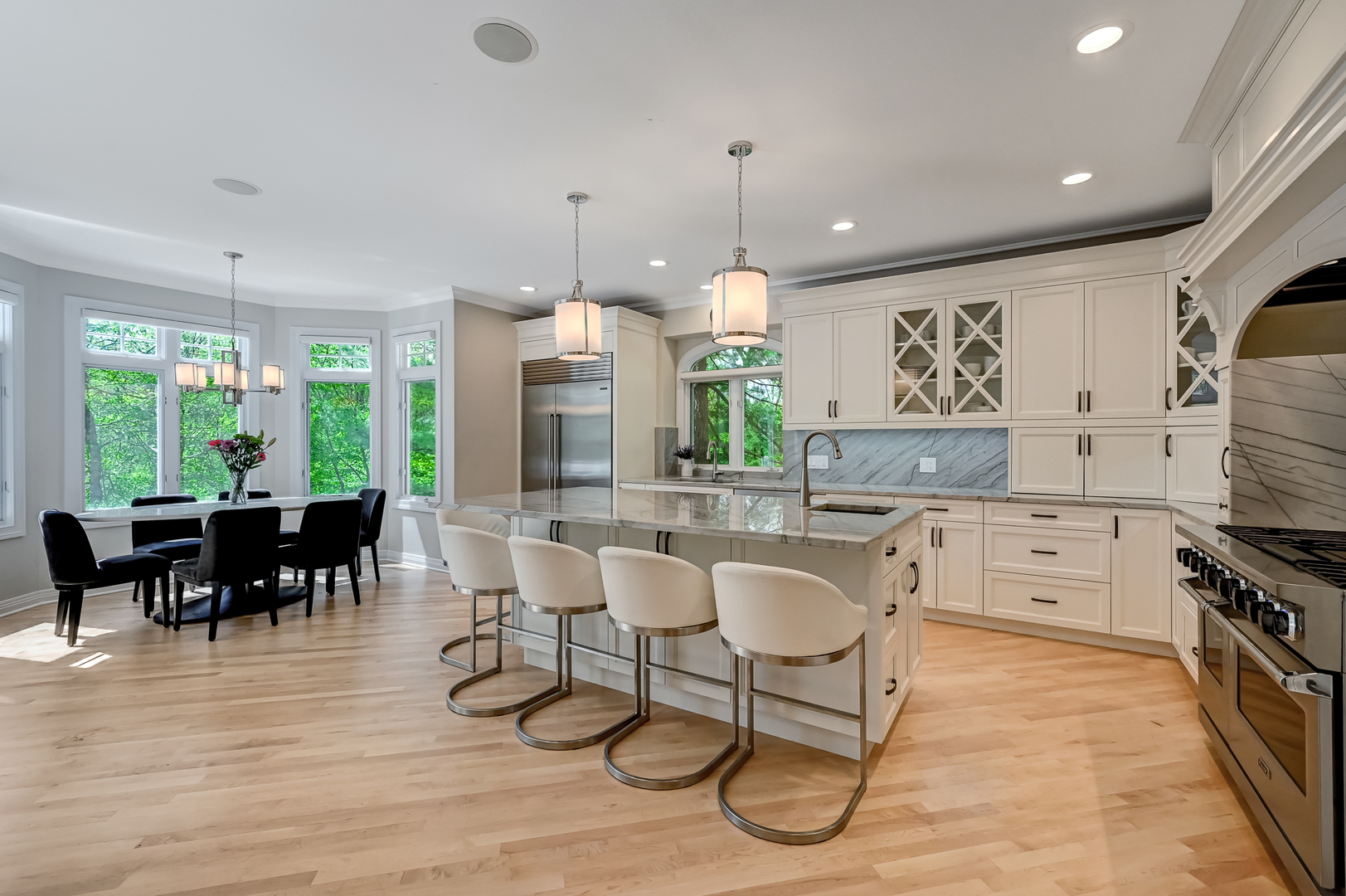 9301 Falling Waters Drive East Burr Ridge, IL 60527 - Photo 15 of 52 a kitchen with stainless steel appliances kitchen island granite countertop a stove a refrigerator a kitchen island a dining table and chairs with wooden floor