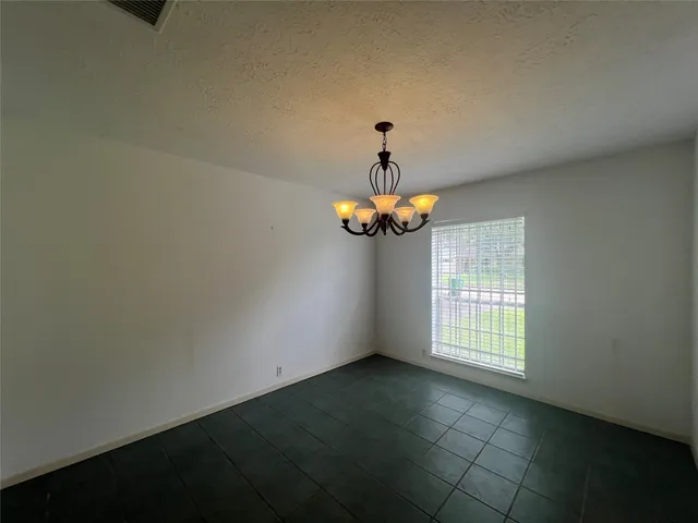 an empty room with windows and chandelier