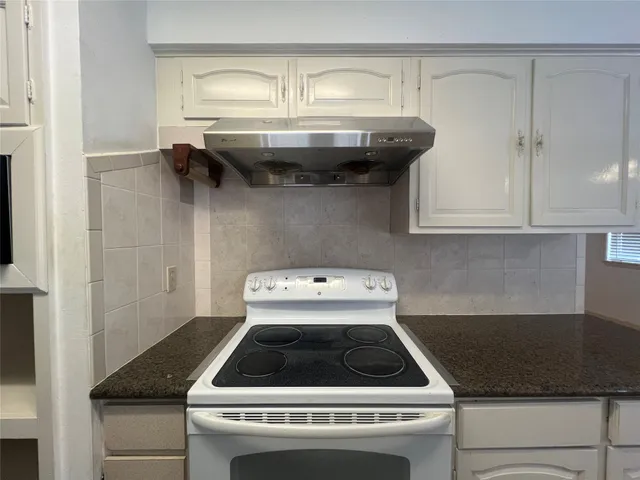 a stove top oven sitting inside of a kitchen