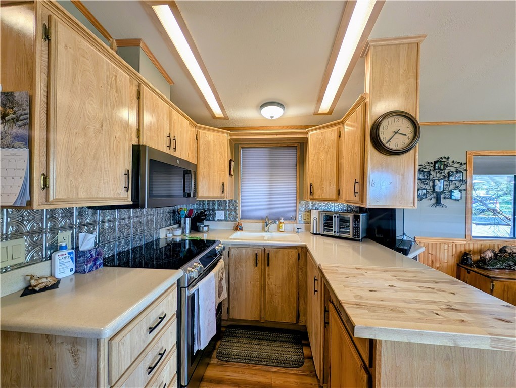 2000 Ramar Road, Unit 89 Bullhead City, AZ 86442 - Photo 14 of 26 Kitchen featuring appliances with stainless steel finishes, light countertops, light brown cabinets, and tasteful backsplash