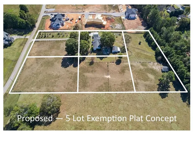a aerial view of a house with a yard and large trees