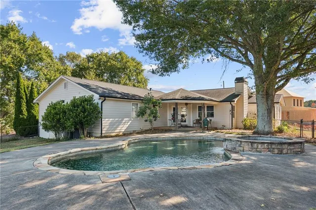 a view of swimming pool with outdoor seating and a garden