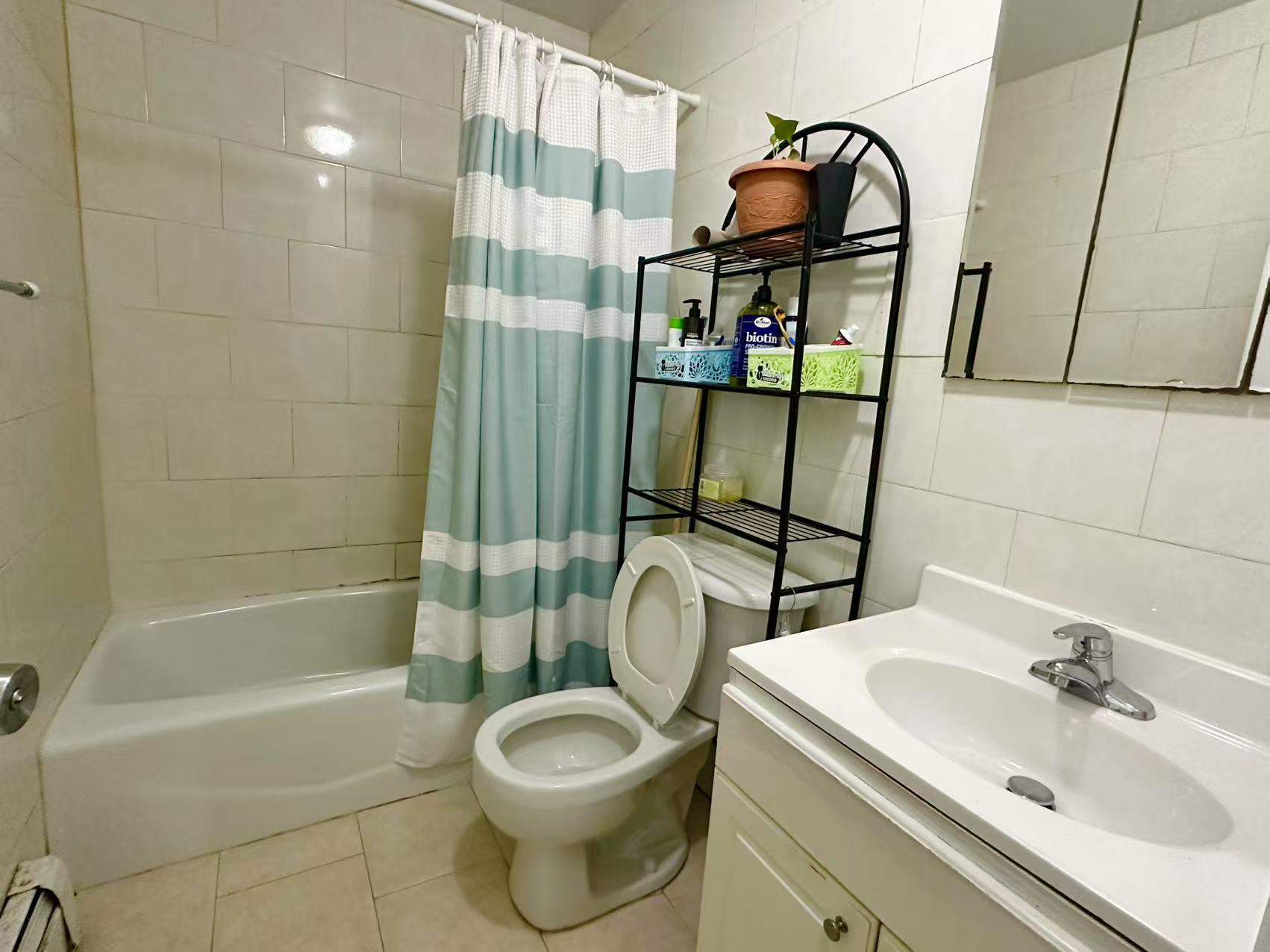 104-48 37th Drive, Unit 2 Queens, NY 11368 - Photo 7 of 15 Full bathroom with tile patterned flooring, tile walls, shower / tub combo with curtain, and baseboard heating