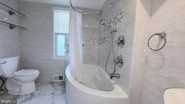 a bathroom with a toilet sink and shower